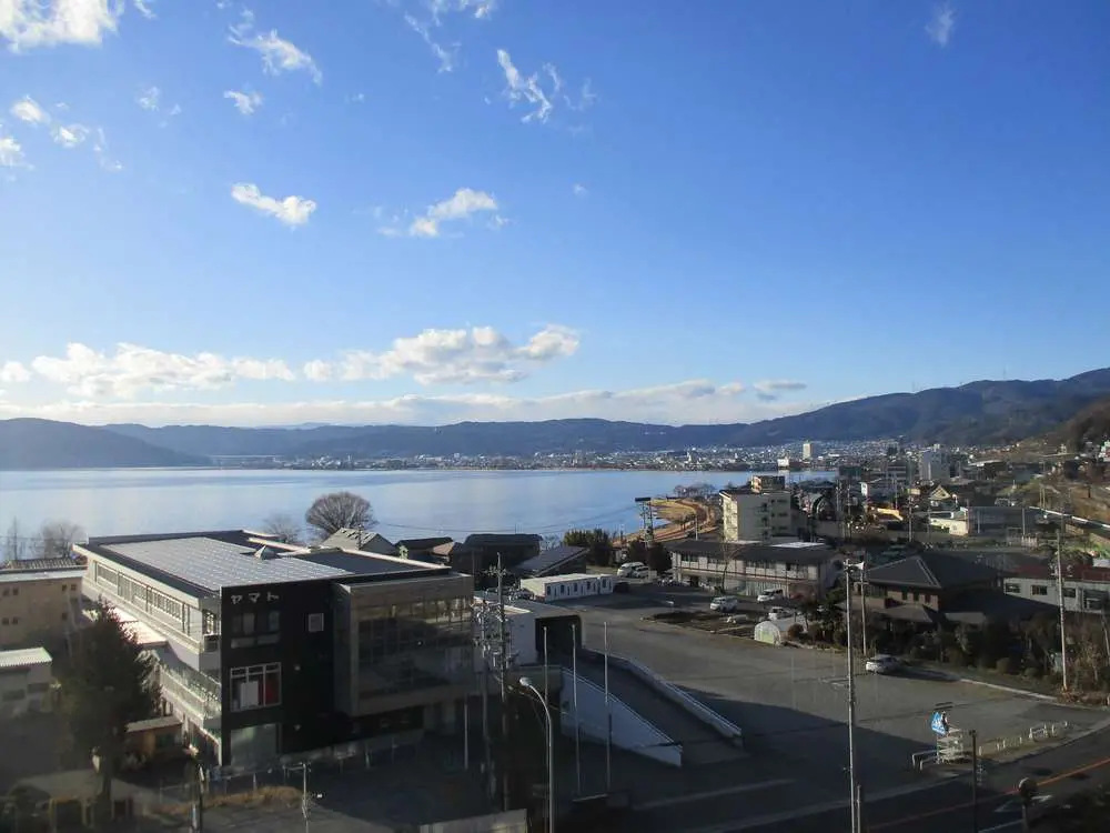 湖畔に立つ介護施設の外観と周辺環境。山々に囲まれた景観地。